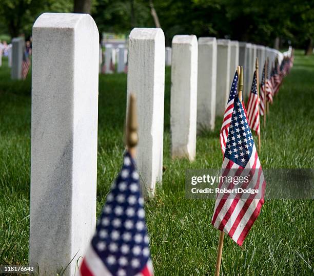 row of soldiers headstones with american flags - arlington national cemetery stockfoto's en -beelden