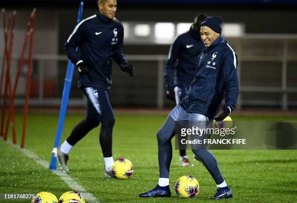 France's forward Kylian Mbappe controls the ball during a training session in Clairefontaine en Yvelines on November 11 as part of the team's...