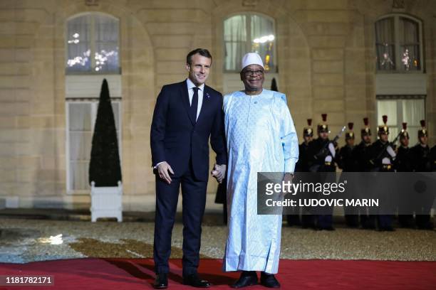 French President Emmanuel Macron greets President of Mali Ibrahim Boubacar Keita prior to a dinner with the participants of the Paris Peace Forum at...