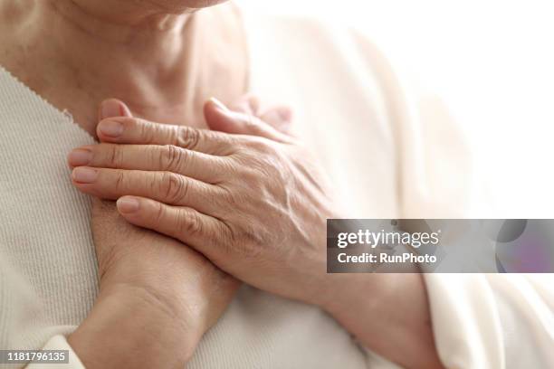 close up of senior woman with hands on chest - hands on chest stock pictures, royalty-free photos & images