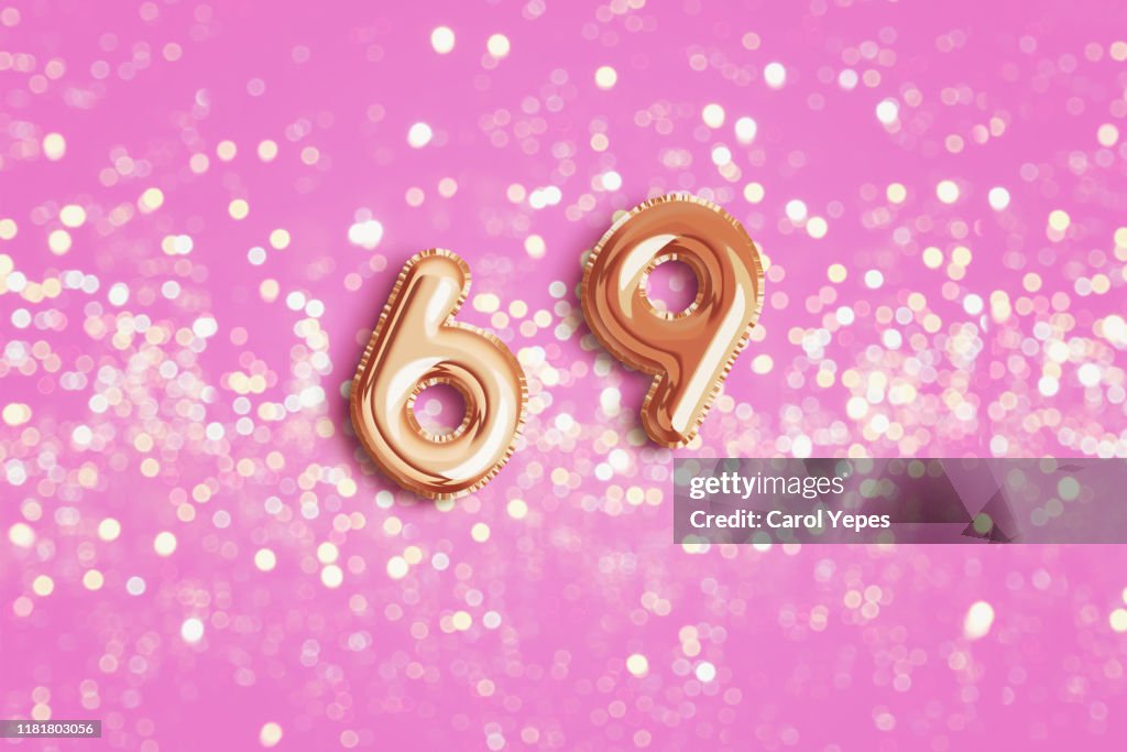 Number 69 in foil ballon.Pink background