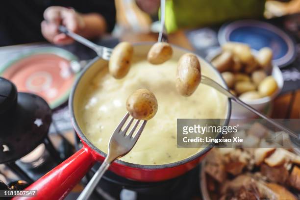 famous swiss cheese fondue with breads and potatoes, landmark of switzerland - fondue stock pictures, royalty-free photos & images