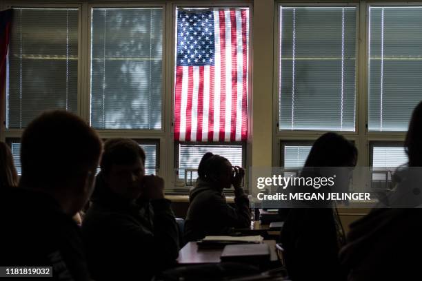 Sidney High School students sit through class under a US flag in Sidney, Ohio, October 31, 2019. - At the entrance to Sidney High School in...