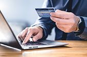 Safe online payment and electronic money transfer security. Pay with digital technology. Man using credit card and laptop to login to internet bank.