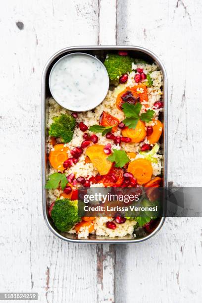 lunchbox with couscous, grilled vegetables, pomegranate seeds and yoghurt mint dip - kuskus stock-fotos und bilder