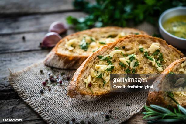 appetizer: garlic bread on rustic wooden table - garlic bread stock pictures, royalty-free photos & images