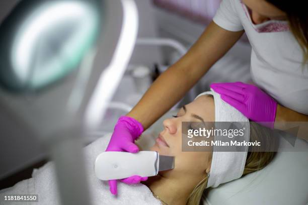 ultrasonic facial cleansing in a beauty salon - peel stock pictures, royalty-free photos & images