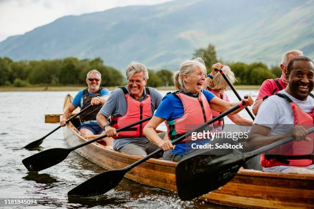 personas mayores disfrutando y divirtiéndose en el barco de remo - rowing fotografías e imágenes de stock