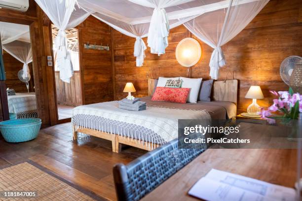 wide shot desk and bedroom of luxury island resort - mosquito netting stock pictures, royalty-free photos & images