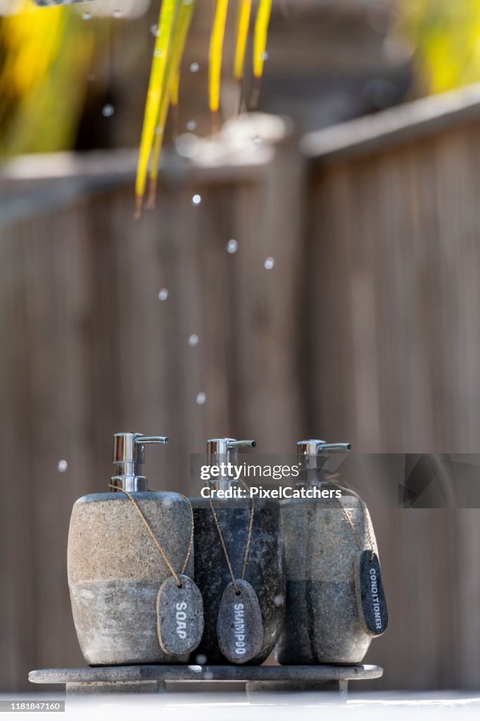 Organic soap dispensers made of stone with palm leaves and water drops