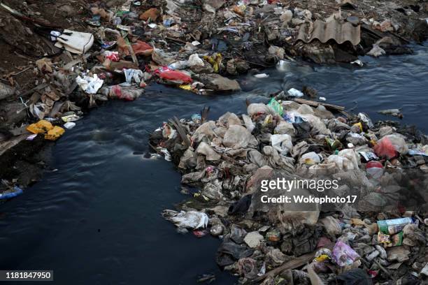 garbage at dirty water - estrecho fotografías e imágenes de stock