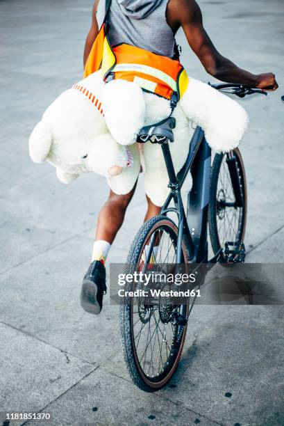 bicycle courier delivering a teddy bear - velo humour stock-fotos und bilder