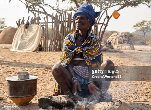 old mucubal woman cooking in the traditional way, tchitundo hulo, virei, angola - angola stock-fotos und bilder