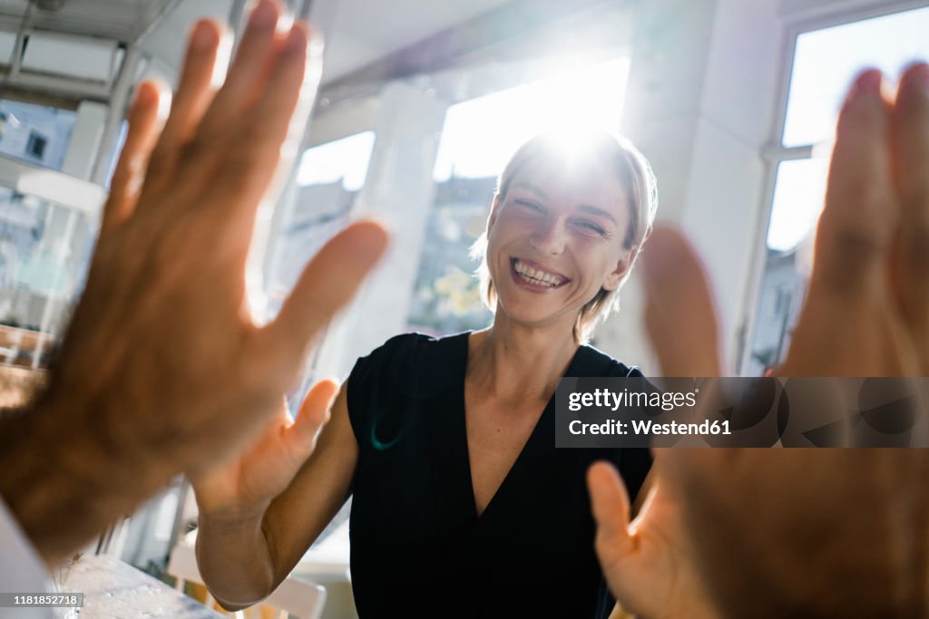 Blond businesswoman high fiving a colleague