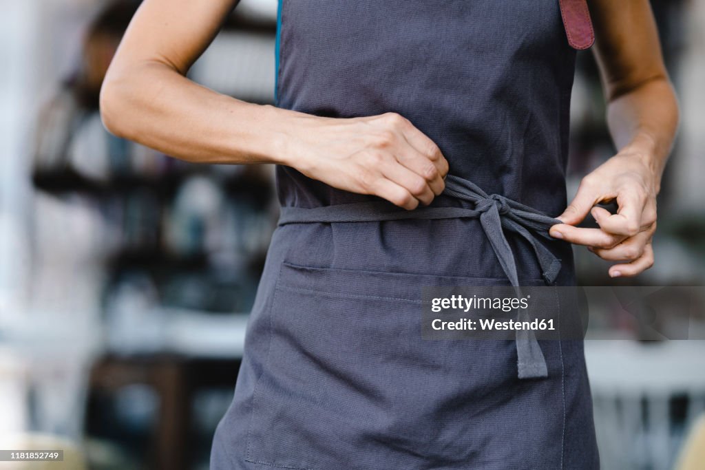 Woman tying her apron before work