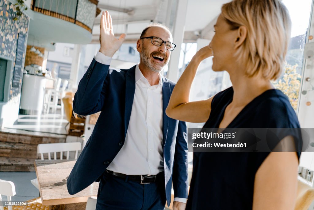 Business people high fiving in a coffee shop
