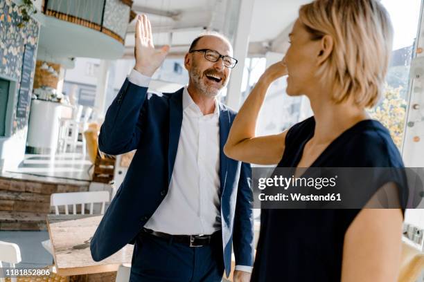 business people high fiving in a coffee shop - dammi un cinque foto e immagini stock