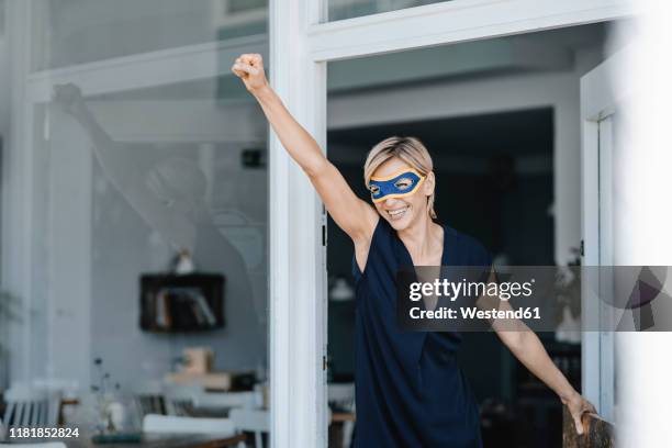 businesswoman wearing super hero masks, pretending to fly - heldin stockfoto's en -beelden