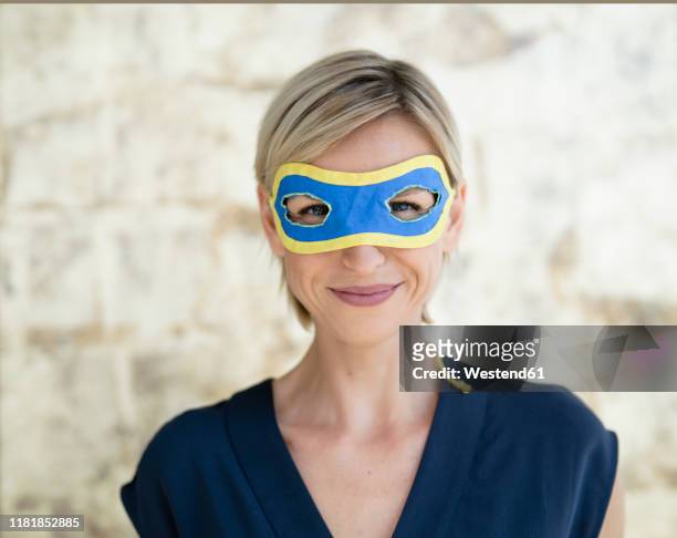 portrait of blond businesswoman, wearing superwoman mask - superwoman stock pictures, royalty-free photos & images