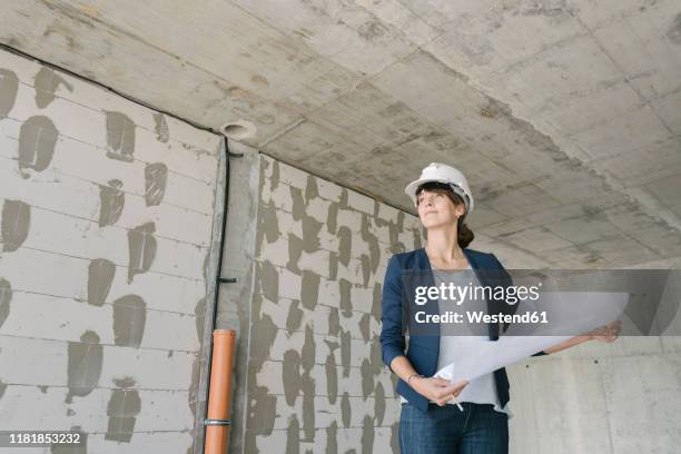 female architect checking architectural plan on construction site - architect on site fotografías e imágenes de stock