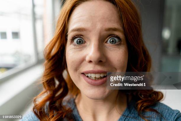 portrait of starring redheaded woman - disbelief stock pictures, royalty-free photos & images
