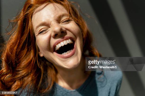 portrait of laughing redheaded woman - aufregung stock-fotos und bilder