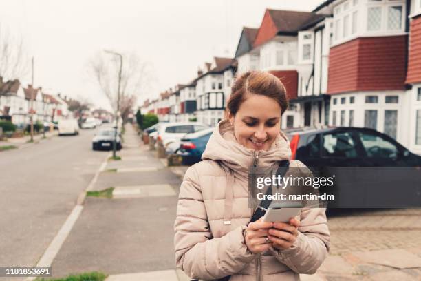 mujer turista en los suburbios de londres enviando mensajes de texto - british culture walking fotografías e imágenes de stock