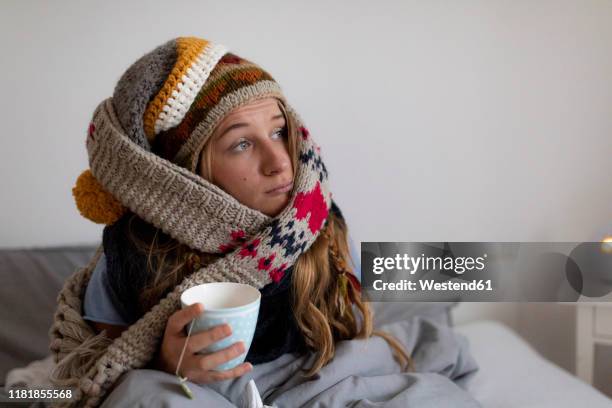 ill young woman drinking tea in bed at home - women touching herself in bed stock pictures, royalty-free photos & images