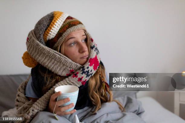 ill young woman drinking tea in bed at home - roupa quente imagens e fotografias de stock