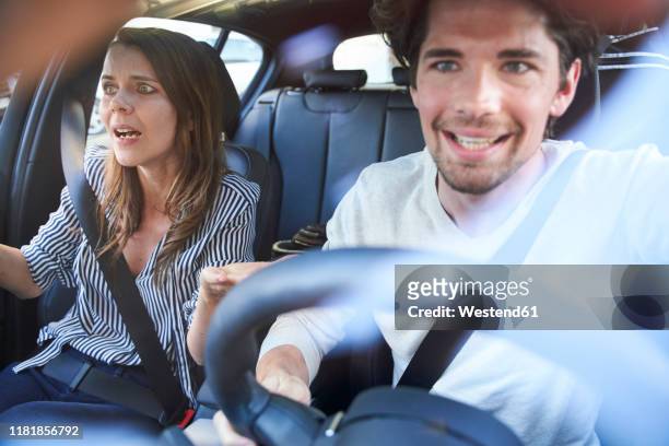 shocked couple in a car with man driving - horrible car accidents stockfoto's en -beelden