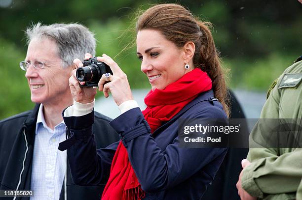 Catherine, Duchess of Cambridge takes photographs as Prince William, Duke of Cambridge takes part in helicopter manouvres called 'water birding'...