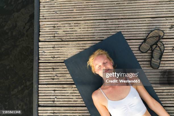 top view of young woman lying on a jetty - boardwalk stock-fotos und bilder