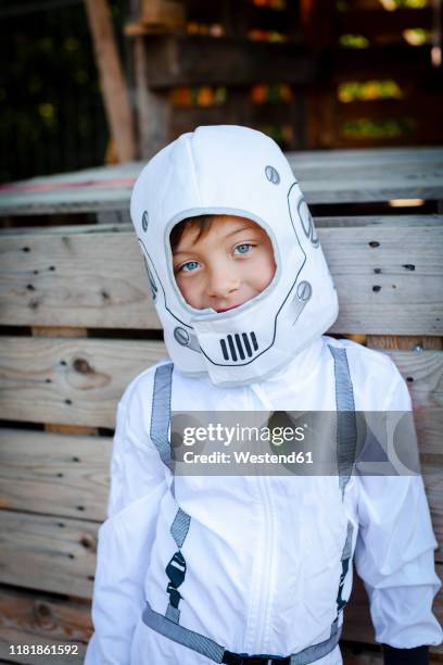 young boy as a superhero, astronaut playing in a tree house - astronaut portrait stock-fotos und bilder