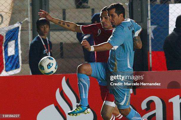 Mauricio Victorino of Uruguay battles for the ball with Jose Guerrero during a match as part of group C of 2011 Copa America at Bicentenarium Stadium...