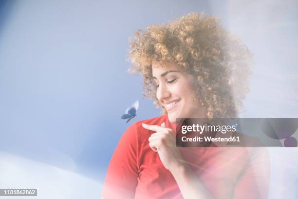 smiling woman with flying butterfly, robot - butterfly hand stock-fotos und bilder