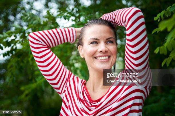 portrait of happy woman with wet hair wearing striped top in nature - older woman wet hair stock pictures, royalty-free photos & images
