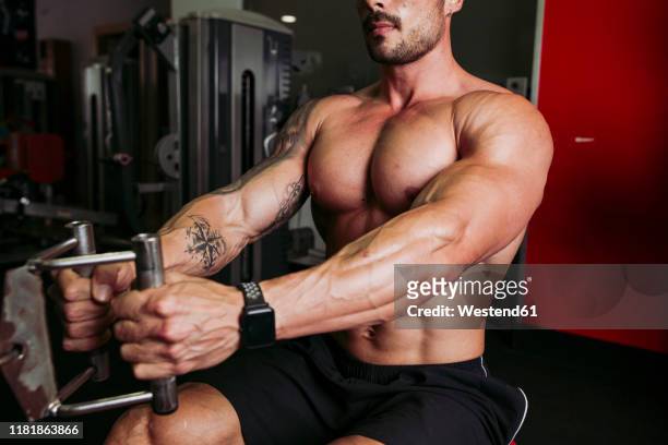 muscular man training in gym - pectoral muscle stockfoto's en -beelden