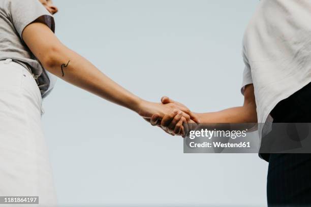 young couple holding hands - naderen stockfoto's en -beelden