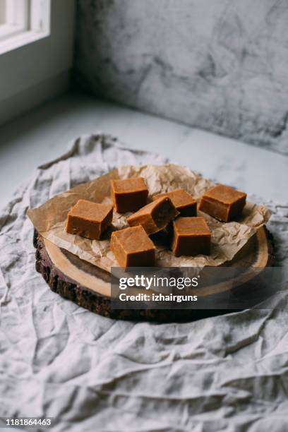 fresh caramel fudge candies on a wooden plate with copy space in marble background - close up of chocolates for sale stock pictures, royalty-free photos & images