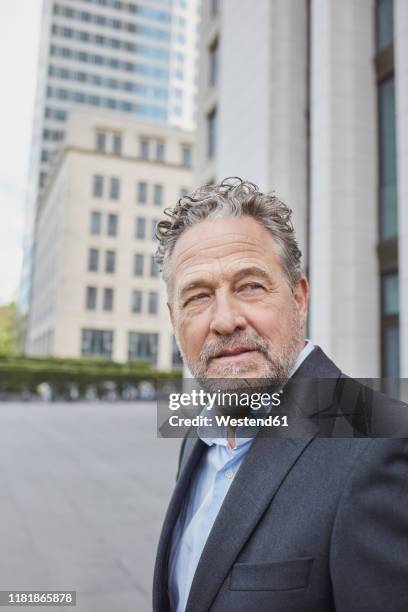 portrait of confident businessman in the city - siegerpose stock-fotos und bilder