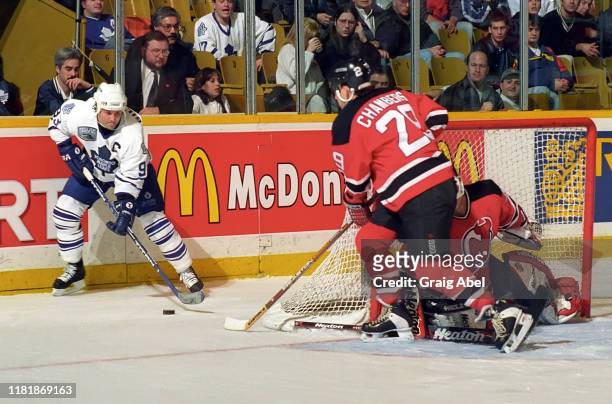 Doug Gilmour of the Toronto Maple Leafs skates against Shawn Chambers and Richard Brodeur of the New Jersey Devils during NHL game action on December...