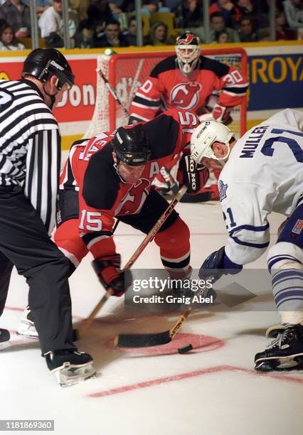 John MacLean and Richard Brodeur of the New Jersey Devils skate against Kirk Muller of the Toronto Maple Leafs during NHL game action on December 10,...