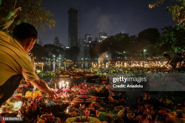 Man releases Krathong onto the water during Loy Krathong festival at Lumphini Park in Bangkok, Thailand on November 11, 2019. The yearly Festival of...