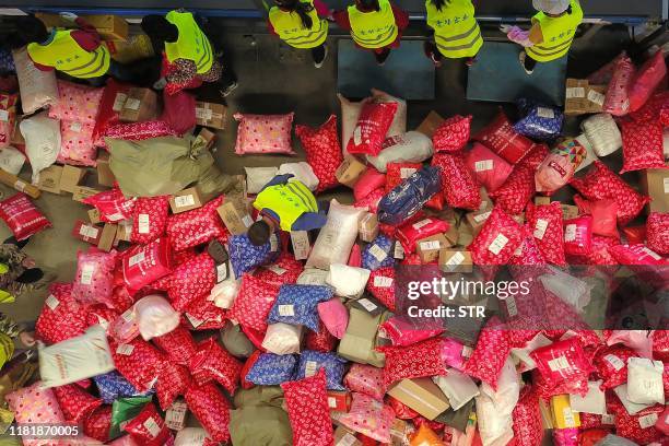 This photo taken on November 11, 2019 shows workers sorting out packages at a delivery company warehouse on "Singles' Day" -- the world's biggest...