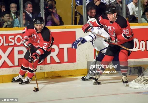 Scott Niedermayer and Shawn Chambers of the New Jersey Devils skate against Darby Hendrickson of the Toronto Maple Leafs during NHL game action on...