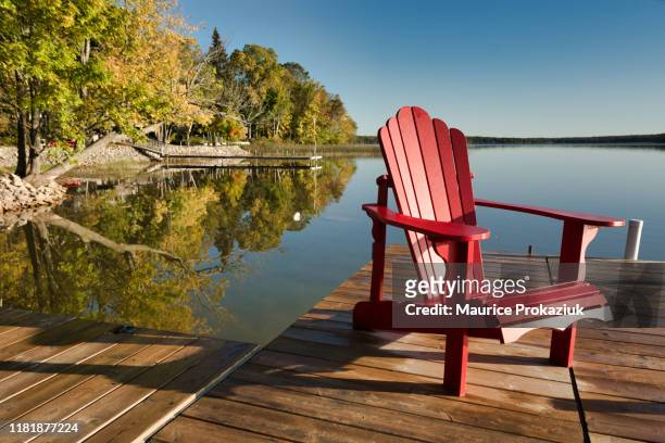 red chair on a dock - cottage imagens e fotografias de stock