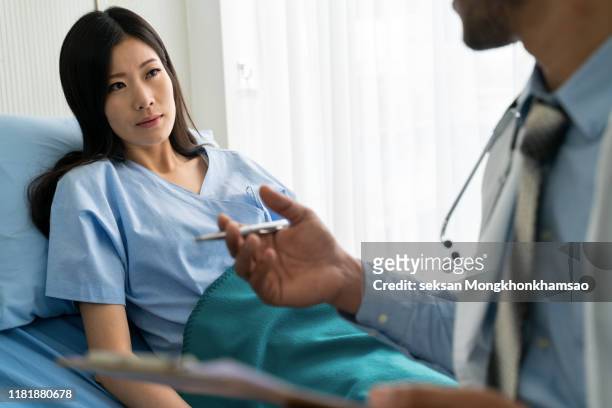doctor consulting male patient, working on diagnostic examination on men's health disease or mental illness, and writing on prescription record information document in clinic or hospital office - prostate cancer stock pictures, royalty-free photos & images