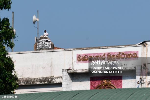 Prisoner displays a banner on the roof of a building inside the Welikada prison in Colombo on November 12 to protest the pardon for man who murdered...