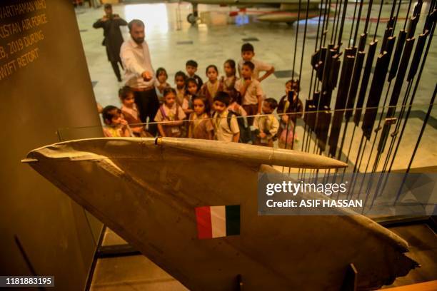 Students look at a part of an Indian Mig-21 fighter aircraft which was being flown by Indian pilot Wing Commander Abhinandan Varthaman whose plane...