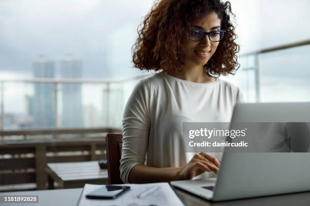 jonge vrouw met laptop in een café - learn arabic stockfoto's en -beelden